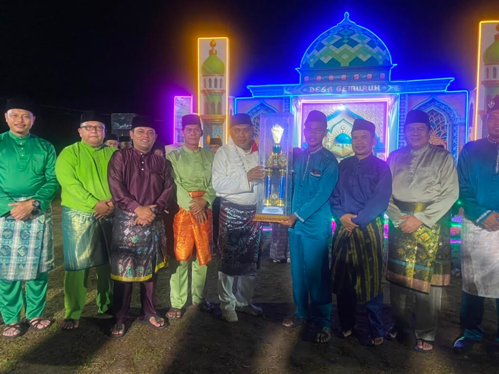 Wakil Bupati Karimun Rocky Bawole bersama panitia, dewan hakim, dan para juara MTQ Tingkat Desa Gemuruh 2026 foto bersama di depan panggung utama saat malam penutupan.